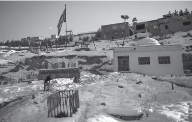  ??  ?? A RESIDENT pushes his bicycle as he climbs up a road going through a snow-covered cemetery in Kabul on January 15, 2020.