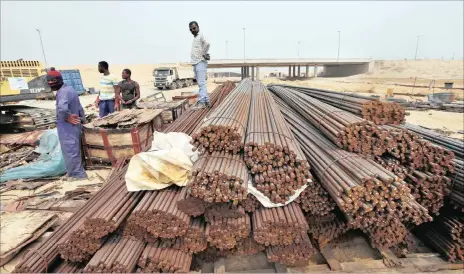  ?? FILE BLOOMBERG ?? Workers wait near supplies of steel reinforcem­ent rods in Lagos, Nigeria. The country aims to boost mining in order to grow its economy.