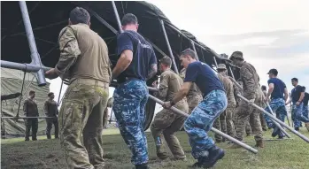  ??  ?? Australian Army soldiers from The 5th Battalion, Royal Australian Regiment and Royal Australian Air Force Base Tindal personnel, construct emergency shelter tents at the Katherine Showground­s.