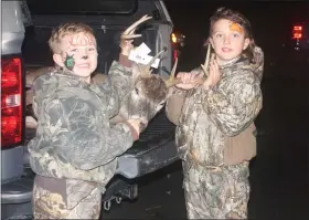  ?? PHOTOS BY DAVID ANGELL—FOR THE MACOMB DAILY ?? Hunter and Hudson Milton inspect an incoming buck at check-in Wednesday night.