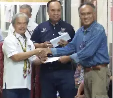  ??  ?? Paulus (left) presents government grant to a longhouse chief.