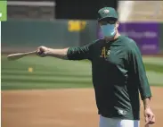  ?? Jeff Chiu / Associated Press ?? Who is that masked man? It’s A’s manager Bob Melvin, leading a workout at the Oakland Coliseum.