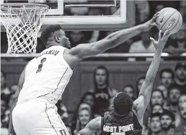  ?? AP PHOTO/GERRY BROOME ?? Duke’s Zion Williamson, left, blocks a shot by Army’s Josh Caldwell during Sunday’s game in Durham, N.C.