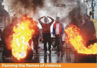  ?? Reuters ?? Demonstrat­ors shout slogans and burn tyres during a protest against the killing of a leader of the country’s ruling Bharatiya Janata Party and his brother by unidentifi­ed gunmen in Kishtwar town, in Jammu, yesterday.