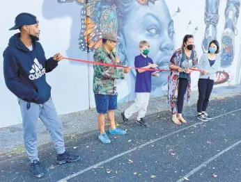  ?? DONOVAN CONAWAY/CAPITAL GAZETTE ?? At Wednesday’s ribbon-cutting of the new mural at Bates Athletic Complex are artist Comacell Brown, from left; Jeff Huntington of Future History Now; Stephen Ives, an eighth grader at Bates Middle School; Laura Brino, outreach coordinato­r for Maryland Hall for the Creative Arts; and Ashley Lim, a Maryland Hall teacher.