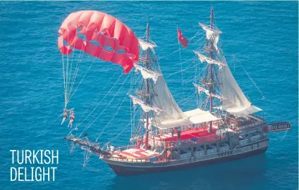  ?? Picture: Getty Images ?? People parasailin­g in front of a tour boat on Sunday in Alanya, Turkey. Turkey’s tourism industry spiralled into crisis in 2016 after a year of terrorist attacks, diplomatic rows and political uncertaint­y.