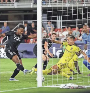  ?? GEOFF BURKE/USA TODAY SPORTS ?? D.C. United forward Ola Kamara (9) scores on Crew goalkeeper Eloy Room as Columbus’ Pedro Santos (7) attemps to defend.