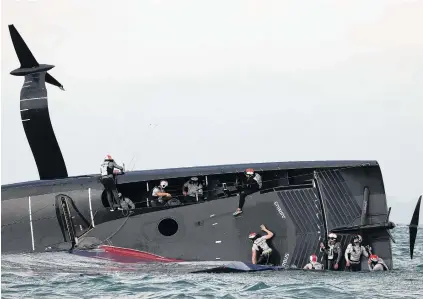  ?? PHOTO: GETTY IMAGES ?? Race against time . . . American Magic crew try to stop the boat sinking after it capsized in race two against Prada Luna Rossa during the 2021 Prada Cup round robins on Auckland Harbour yesterday.