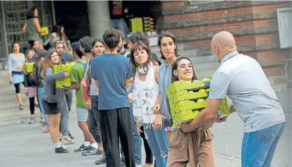  ?? REUTERS ?? Víveres. Padres de alumnos de una primaria en Barcelona, con provisione­s para el fin de semana.
