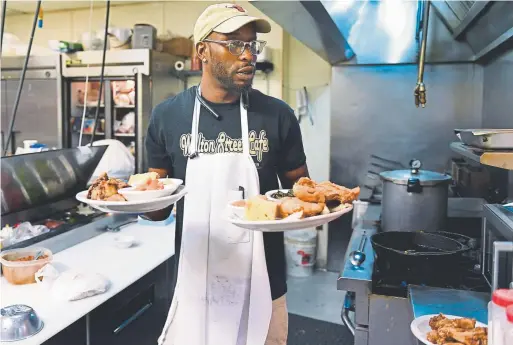  ?? Photos by Joe Amon, The Denver Post ?? Fathim Dickerson turns out servings of oxtail stew and fried chicken at lunch at Welton Street Cafe on June 7.