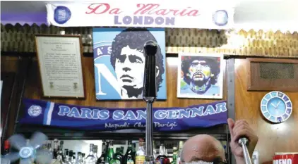  ??  ?? A bar tender prepares an espresso coffee inside the Bar Nilo where a makeshift shrine of soccer legend and former Napoli player Diego Armando Maradona is displayed, in downtown Naples. Photo: AP