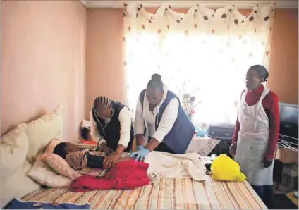  ??  ?? Helping hands: Nurse Maria Malahela and community health worker Xolile Dlamini provide bed-ridden Busisiwe Ndimande with home-based care three times a week. Photos: Oupa Nkosi