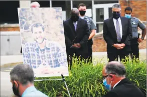  ?? Matthew Brown / Hearst Connecticu­t Media ?? A portrait of probation officer Jonathan Coehlo is displayed as attendees observe a moment of silence in his honor during a memorial service outside the Superior Courthouse in Stamford on Wednesday.