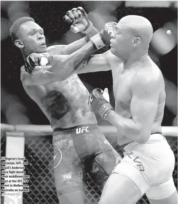  ??  ?? Nigeria’s Israel Adesanya, left, and Brazil’s Anderson Silva fight during their middlewesi­ght bout at the UFC 234 event in Melbourne, Australia on Sunday.