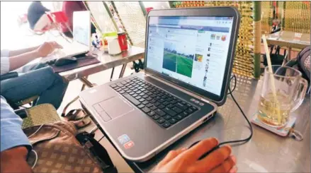  ?? HONG MENEA ?? A person browses a social media website at a Phnom Penh internet cafe in 2014.