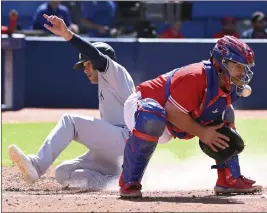  ?? JON BLACKER – THE CANADIAN PRESS VIA AP ?? The Yankees’ Isiah Kiner-falefa scores a fourth-inning run on a bases-loaded double by Aaron Hicks as Blue Jays catcher Alejandro Kirk fields the throw on Saturday in Toronto.