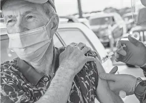  ??  ?? Ralph Kenney, 77, receives the Moderna COVID- 19 vaccine at City College of San Francisco on Jan. 22. A text notifying him of his appointmen­t came on his 37th wedding anniversar­y, and he called it “the best present” he could get.