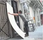  ?? JOE RAEDLE/GETTY IMAGES ?? Marris Mielnick covers windows in the French Quarter of New Orleans before the storms.