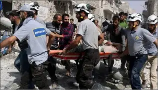  ??  ?? Rescue workers at the site of air strikes in eastern Aleppo.
