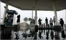  ?? THE ASSOCIATED PRESS ?? People watch heavy rain from the relative safety of a flooded gas station caused by Tropical Storm Harvey on Sunday in Houston.