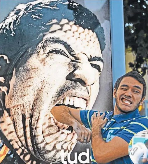  ?? AFP ?? DIENTE POR DIENTE. Un turista juega con la imagen de Suárez en la playa de Copacabana, en Río de Janeiro.