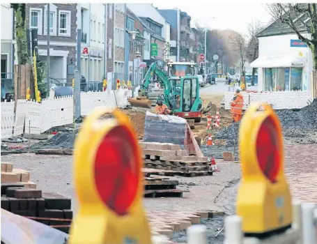  ?? RP-FOTOS: ARMIN FISCHER ?? Noch sieht’s wild aus, aber ein Ende ist in Sicht: Die Löcher sind gestopft, der Boden für die Neue Mitte ist bereitet. Silvester soll die Sperrung der Burgstraße aufgehoben sein.