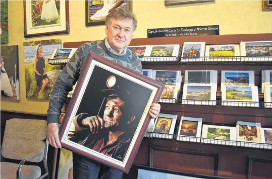  ?? ELIZABETH PATTERSON • CAPE BRETON POST ?? Although famed for his scenic photograph­y, Warren Gordon holds what is perhaps his most famous photo, of miner Fabian Young, taken months before his death in a coal mining tragedy.