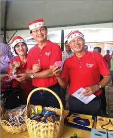  ??  ?? Baru (centre), flanked by his wife Yu Ching Sieu and Zehegkiel together hold some of the items displayed at an exhibition booth.