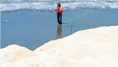  ?? The STAR ?? A worker prepares the white sand at the Manila Bay, which has been under rehabilita­tion since January 2019.