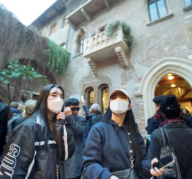  ?? (Foto Sartori) ?? Tour turistico con la mascherina Due turiste cinesi nel cortile dalla Casa di Giulietta