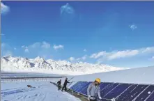  ?? PROVIDED TO CHINA DAILY ?? Workers clear snow from photovolta­ic panels at a photovolta­ic power station in Kashgar, Xinjiang Uygur autonomous region, in November 2021.