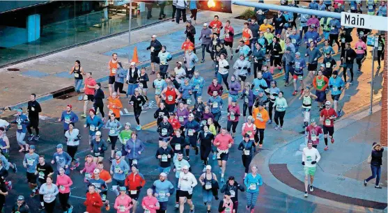  ?? [PHOTO BY BRYAN TERRY, THE OKLAHOMAN] ?? Runners head south Sunday morning on Robinson during the Oklahoma City Memorial Marathon.