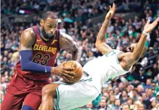  ?? Michael Dwyer/Associated Press ?? ■ Cleveland Cavaliers forward LeBron James (23) drives against the defense of Boston Celtics forward Marcus Morris during the first quarter of Game 1 of the NBA Eastern Conference Finals on Sunday in Boston.