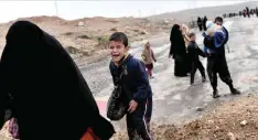  ??  ?? MOSUL: Iraqi families walk down a road as they flee Mosul during an offensive by security forces to retake the western parts of the city from Islamic State (IS) group fighters. — AFP