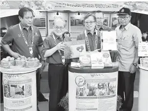  ?? — Gambar Chimon Upon ?? BISI KUALITI: Abang Johari enggau Uggah ngayanka produk tauka asil betanam betupi ke udah digred, dibungkus enggau dilabel enggau manah, seraya diperatika (kiba) Dr Abdul Rahman sereta (belakang) Abdullah, pengudah bejadi Atur GPL ba Nengeri Sarawak nyerumba Sarawak AgroFest 2018, kemari.