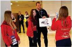  ??  ?? One for the cameras: Kane poses with a volunteer and an artwork of himself with the Golden Boot in St Petersburg