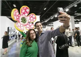  ?? MATIAS J. OCNER mocner@miamiheral­d.com ?? Michele Scheck and husband Steven Scheck take a selfie next to ‘Flowers that speak all about my heart given to the sky’ by Yayoi Kusama during the 2019 Art Basel Miami Beach.