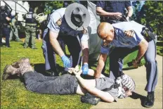  ?? MIKE STEWART/AP ?? GEORGIA STATE PATROL OFFICERS detain a protester on the campus of Emory University during an pro-palestinia­n demonstrat­ion on Thursday in Atlanta.
nd