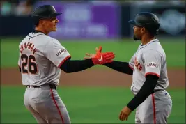  ?? BRANDON SLOTER — GETTY IMAGES ?? Matt Chapman (26) of the San Francisco Giants is congratula­ted by LaMonte Wade Jr. (31) after hitting a two-run home run in the first inning against the San Diego Padres at Petco Park on Friday in San Diego.