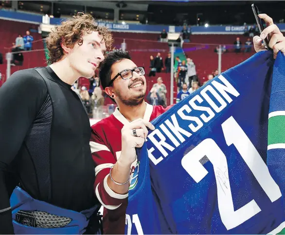  ?? PHOTOS: JEFF VINNICK/ NHLI VIA GETTY IMAGES ?? Loui Eriksson, who joined the Canucks in July to play with the Sedin twins, poses for a selfie with the fan who won his game jersey on shirt-off-your-back night after the Canucks beat the Carolina Hurricanes Oct. 16. Vancouver won 4-3 in overtime.