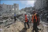  ?? MOHAMMED TALATENE/DPA VIA ZUMA PRESS ?? Palestinia­n paramedics inspect the remains of Al-Jalaa tower, which housed several media outlets including the Associated Press, after it was hit by an Israeli airstrike on Saturday.