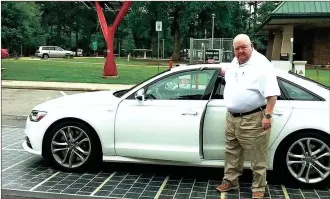  ??  ?? John Robinson of Mobile, Ala., parks his car on a solar road surface in front of a “solar tree” at the West Point, Georgia, visitors center on Interstate 85. New technologi­es for green, sustainabl­e highways are being tested near the Georgia-Alabama...