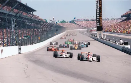  ?? AP FILE ?? In this 1994 photo, Al Unser Jr., front, leads Emerson Fittipaldi into the first turn at the start of the 78th running of the Indianapol­is 500. ABC-TV has been there to document the event every year since 1965.