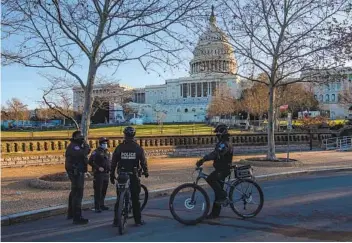  ?? NICHOLAS KAMM AFP VIA GETTY IMAGES ?? Members of the Capitol Police and the Secret Ser vice talk in front of the U.S. Capitol. Thousands of National Guard troops and police and tactical officers will be providing security before and during the inaugurati­on.