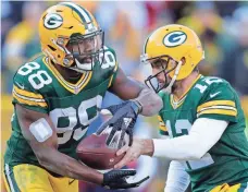  ?? WM. GLASHEEN, USA TODAY NETWORK ?? Ty Montgomery, getting the handoff from quarterbac­k Aaron Rodgers, has revitalize­d the Packers’ running game.