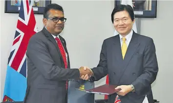  ??  ?? The Permanent Secretary in the Office of the Prime Minister, Yogesh Karan and the Ambassador of Japan. H.E. Masahiro Omura during the signing ceremony at the PM’s Office, Government Buildings, Suva.