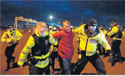  ?? FACUNDO ARRIZABALA­GA / EFE ?? Un hombre es arrestado en la entrada del puerto de Dover, donde miles de camiones siguen bloqueados.