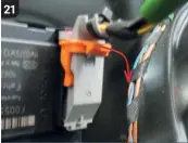 ??  ?? A large plug is connected to the power window motor. Remove this electrical connector by swinging the orange lever out and down, following the direction of the red arrow in this picture.