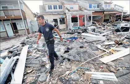  ?? AP PHOTO ?? Firefighte­r Austin Schlarb performs a door to door search in the aftermath of Hurricane Michael in Mexico Beach, Fla., Thursday.