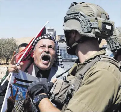  ?? Mussa Qawasmirma / Reuters ?? Un palestí protesta davant uns soldats israelians.
